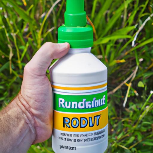 A person holding a bottle of Roundup herbicide for weed control.